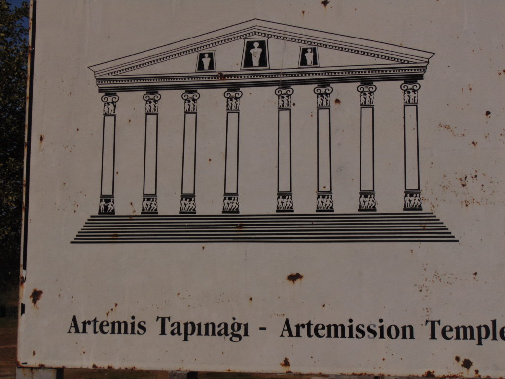 Picture of the sign adjacent to the ruins of the Temple of Artemis showing what the temple structure would have looked like.