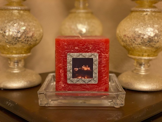 Picture of travel photos adhered to a candle to preserve trip memories.